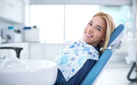 Lächelnder und zufriedener Patient in einer Zahnarztpraxis nach der Behandlung