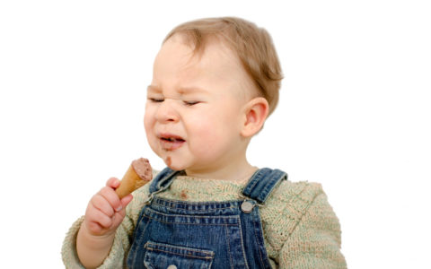 Baby isst Eis und kleckert