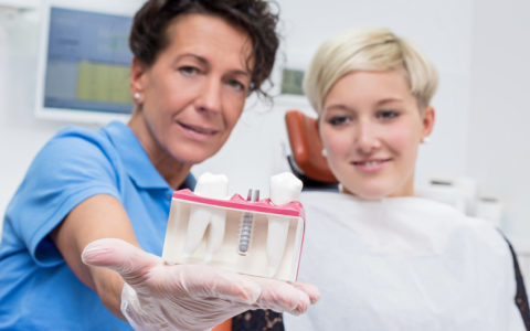 Zahnärztin bespricht mit Patientin ein Implantat