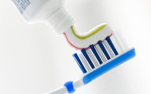 Zahnbürste und Zahnpasta auf unscharfem Hintergrund mit Kopierfeld