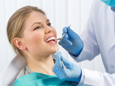 Frau wird beim Zahnarzt behandelt