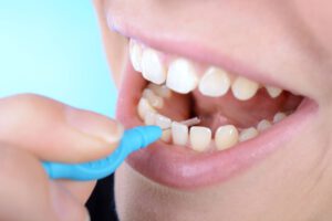 Frau reinigt mit Zahnseide die Zahnzwischenräume