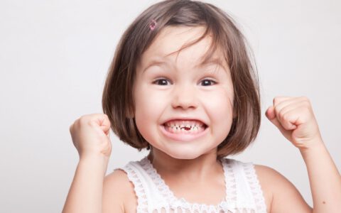 Kleines Mädchen mit Zahnlücke, das sich freut